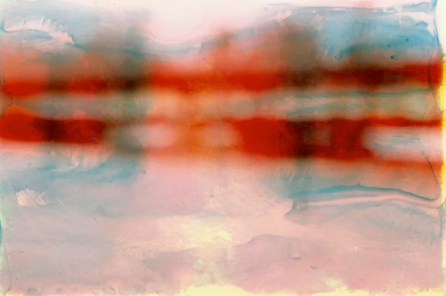 Blurred and abstracted image of a bridge over water.
