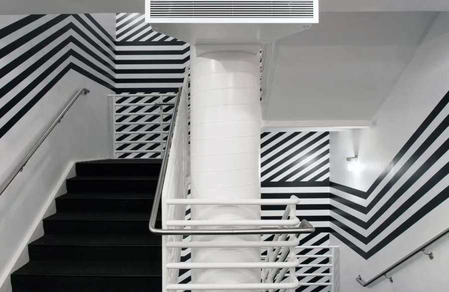 Black and white graphic covering walls of white stairwell.